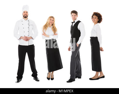 Portrait Of Happy Young du Restaurant Standing Over White Background Banque D'Images