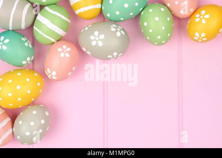 Oeuf de Pâques Pastel frontière contre l'angle d'un fond de bois de rose Banque D'Images