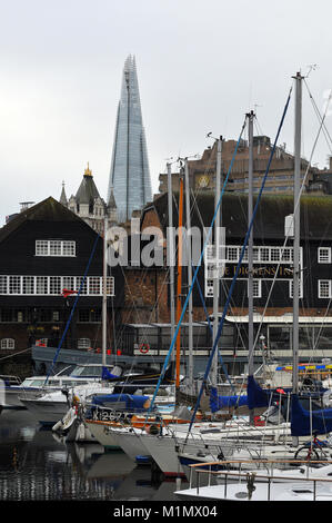 St Catherine's dock sur la Tamise dans le centre de Londres avec le fragment célèbre immeuble de bureaux s'élevant au-dessus de bâtiments historiques dans la distance. Banque D'Images