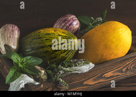 Le Melon, basilic, menthe, violet aubergine graffiti, l'oignon et de basilic frais vert dans une boîte en bois dans un fond de bois dans un style rustique, sélective f Banque D'Images