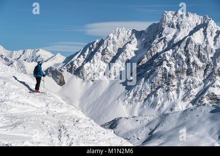 Ski hors piste près de Meribel dans le domaine skiable des Trois Vallées en France. Un skieur se trouve au sommet d'une pente raide. Banque D'Images