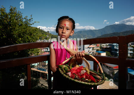 Jeune fille au Népal avec panier de fleurs Banque D'Images