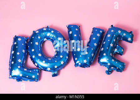 Un peu de bleu en forme de lettre à motifs de ballons à étoiles blanches formant le mot amour contre un fond rose Banque D'Images