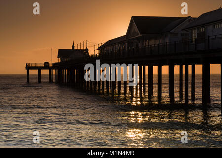 Le soleil se lève juste derrière la jetée de Southwold, Suffolk, Angleterre Banque D'Images