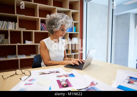 Senior businesswoman working on laptop in office Banque D'Images