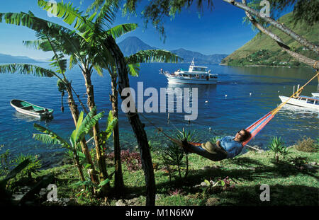 Le Guatemala. Panajachel. Lago de Atitlan. Femme, touristiques en hamac relaxant. Volcan. Ferry. Banque D'Images