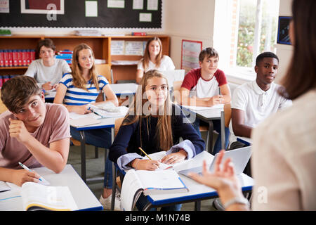 Les élèves à l'écoute de l'enseignant en classe femelle Banque D'Images