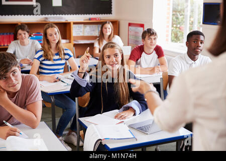 Female Student Raising Hand à poser question In Classroom Banque D'Images