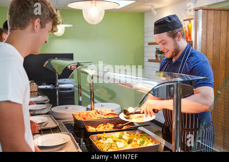 Étudiants adolescents d'être servi en repas de cantine scolaire Banque D'Images