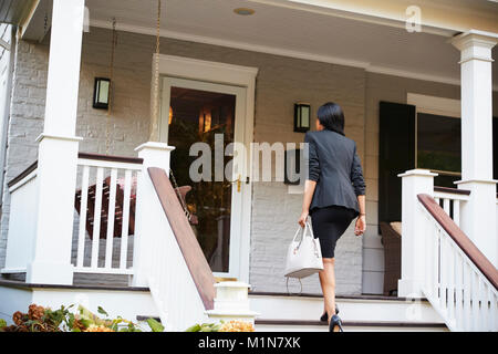 Businesswoman Retourner à Suburban House après le travail Banque D'Images