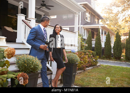 Business Couple laissant Suburban House pour se rendre au travail Banque D'Images