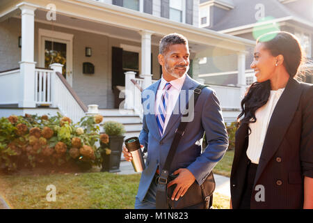 Business Couple laissant Suburban House pour se rendre au travail Banque D'Images