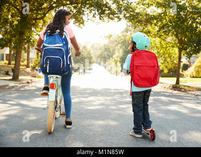 Avec sœur Frère Riding Scooter et vélo à l'école Banque D'Images