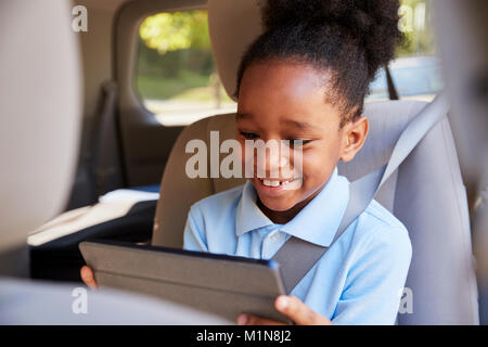 Boy Using Digital Tablet sur Voiture Banque D'Images