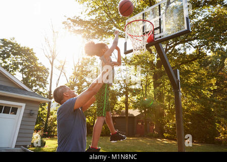 Père et fils jouer au basket-ball sur l'entrée à la maison Banque D'Images