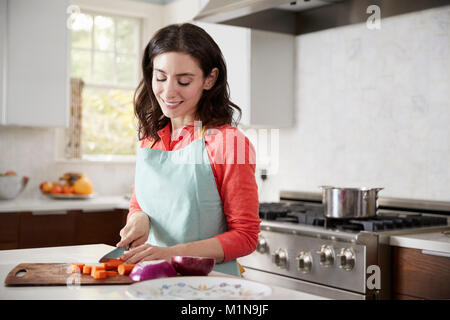 Couper les carottes en femme cuisine pour le repas de la pâque juive Banque D'Images