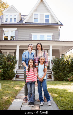 Portrait Of Smiling Family debout devant leur maison Banque D'Images