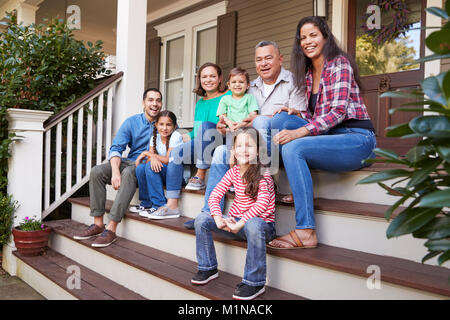 Multi Generation Family s'asseoir sur les marches menant au porche Maison Banque D'Images