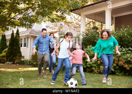 Multi Generation Family Playing Soccer in Garden Banque D'Images