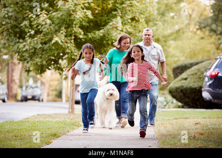 Les grands-parents et les petites-filles Walking Dog Le Long Street Banque D'Images