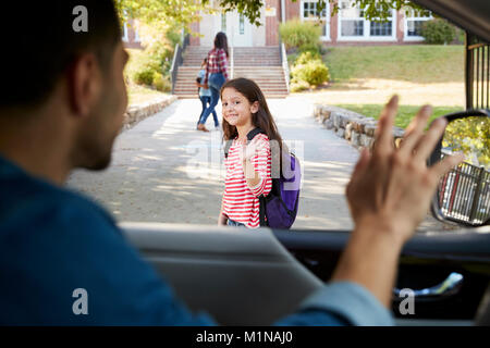 Père en voiture de tomber en face de fille d'école Banque D'Images