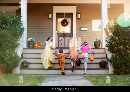 Enfants vêtus de costumes d'Halloween trick or treating Banque D'Images