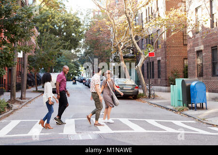 Groupe d'amis Crossing Urban Street à New York City Banque D'Images