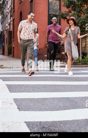 Groupe d'amis Crossing Urban Street à New York City Banque D'Images