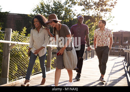 Groupe d'amis à marcher le long pont en milieu urbain Banque D'Images