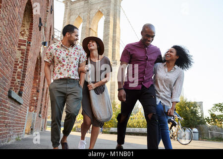 Groupe d'amis à pied par le pont de Brooklyn à New York City Banque D'Images