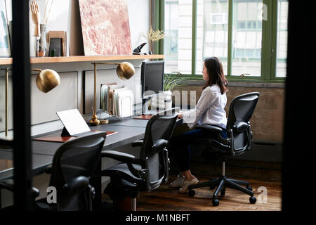 Jeune femme travaillant seul dans un bureau compact Banque D'Images