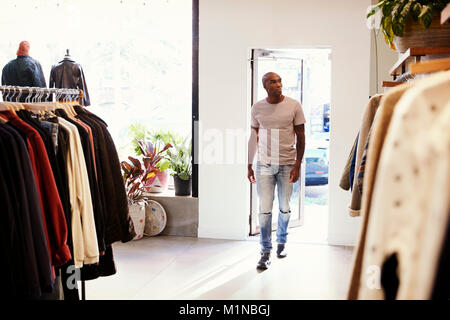 Jeune homme noir la marche dans un magasin de vêtements Banque D'Images