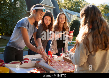 Les filles de l'adolescence le partage d'une pizza dans un quartier block party Banque D'Images