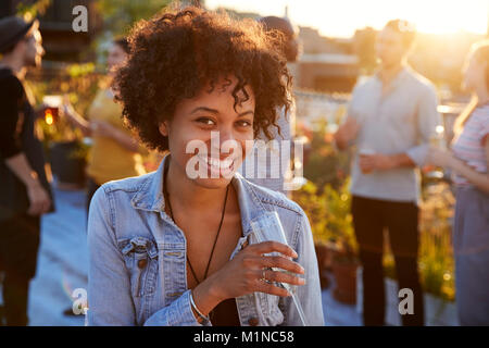 Jeune femme noire à un toit-party smiling to camera Banque D'Images