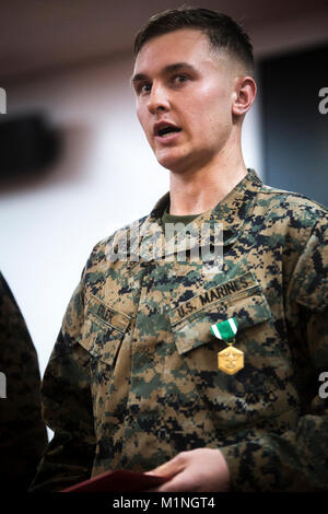 Le Sgt. Justin Erler grâce le lieutenant général Lawrence D. Nicholson, le général commandant du III Marine Expeditionary Force, et d'autres marines après réception de la Marine et le Marine Corps Médaille 3 Janvier 2017 Camp de Courtney, Okinawa, Japon. Erler, opérateur d'équipement lourd avec le Siège et Service Company, 3e Bataillon de Reconnaissance, 3e Division de marines, a reçu le prix pour son action en sauvant la vie de Master Sgt. Hector Trujillo qui a été blessé sur les lieux d'un accident de voiture sur l'autoroute Okinawa après avoir essayé de sauver la vie d'une collectivité locale le 1 décembre 2017, Okinawa. (U.S. Marine Banque D'Images