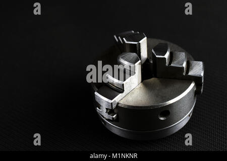 3 jaw chuck pour tour à métaux sur fond noir. Fond d'image industrielle horizontale avec l'espace pour le texte. Banque D'Images