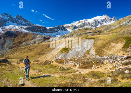 Randonneur marche sur une vallée colorée avec superbe vue panoramique et des couleurs vives. Prise de vue au grand angle dans les Alpes italiennes. Banque D'Images