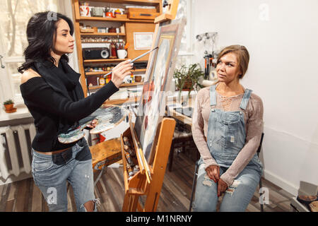 Deux filles dans un studio d'artiste Peintures model. Banque D'Images