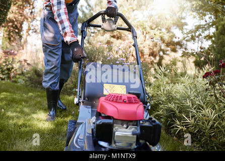 Méconnaissable sur la faucheuse tournant jardinier Banque D'Images