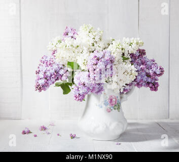 Bouquet de lilas en pot en céramique blanche en bois contre un Wal Banque D'Images