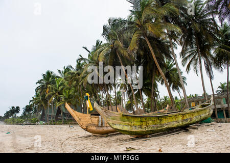 Bateaux de pêche sur une plage bordée de palmiers à Assinie, Côte d'Ivoire, Afrique de l'Ouest, l'Afrique Banque D'Images