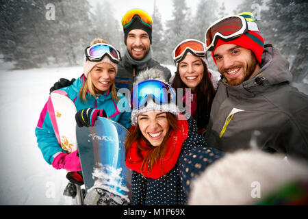 Group of smiling friends having fun sur la neige. Skieurs et snowboardeurs faisant selfies Banque D'Images