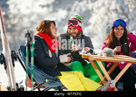 Les personnes gaies s'amuser après le ski en montagne resort avec le matériel de déneigement Banque D'Images