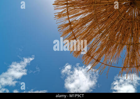 Jusqu'à la paille dans le parasol et le bleu du ciel. Cette scène a été prise sur la plage de sable sur le Sal au Cap Vert. Banque D'Images