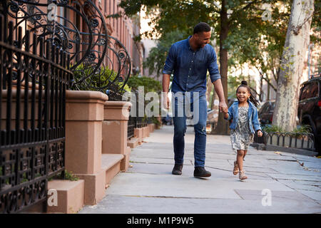 Père et fille de prendre une marche dans la rue Banque D'Images