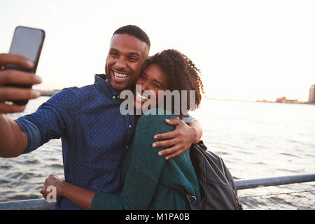 Jeune black couple taking photo sur quai, vue avant Banque D'Images