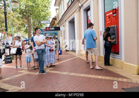 Les gens d'attente, d'autres à une distance respectueuse, à un guichet automatique de la banque. Festival de musique country de Tamworth, Australie. Banque D'Images