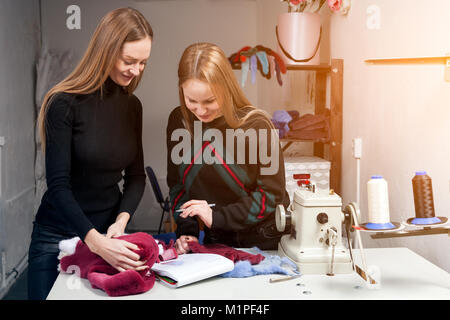 Deux jeunes femmes fourreurs discutons comment bien couper la fourrure naturelle de faire une femme de manteau de fourrure. Le processus de création d'un manteau de fourrure femme Banque D'Images