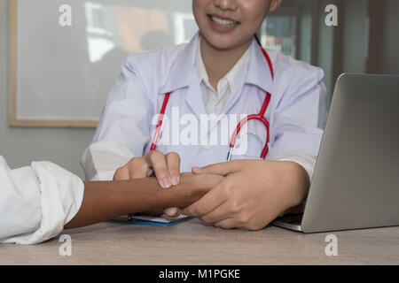 Contrôle d'impulsions de fréquence cardiaque médecin sur le patient à l'hôpital. poignet pulsations mesure médecin à la clinique de soins de santé check up. Banque D'Images