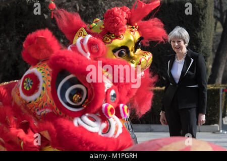 Premier ministre Theresa peut 'Dots' l'œil d'un dragon chinois, un rituel traditionnel de l'éveil d'un dragon, dans l'enceinte de l'ambassade britannique à Beijing aujourd'hui le deuxième jour de trois jours de mission commerciale en Chine. Banque D'Images